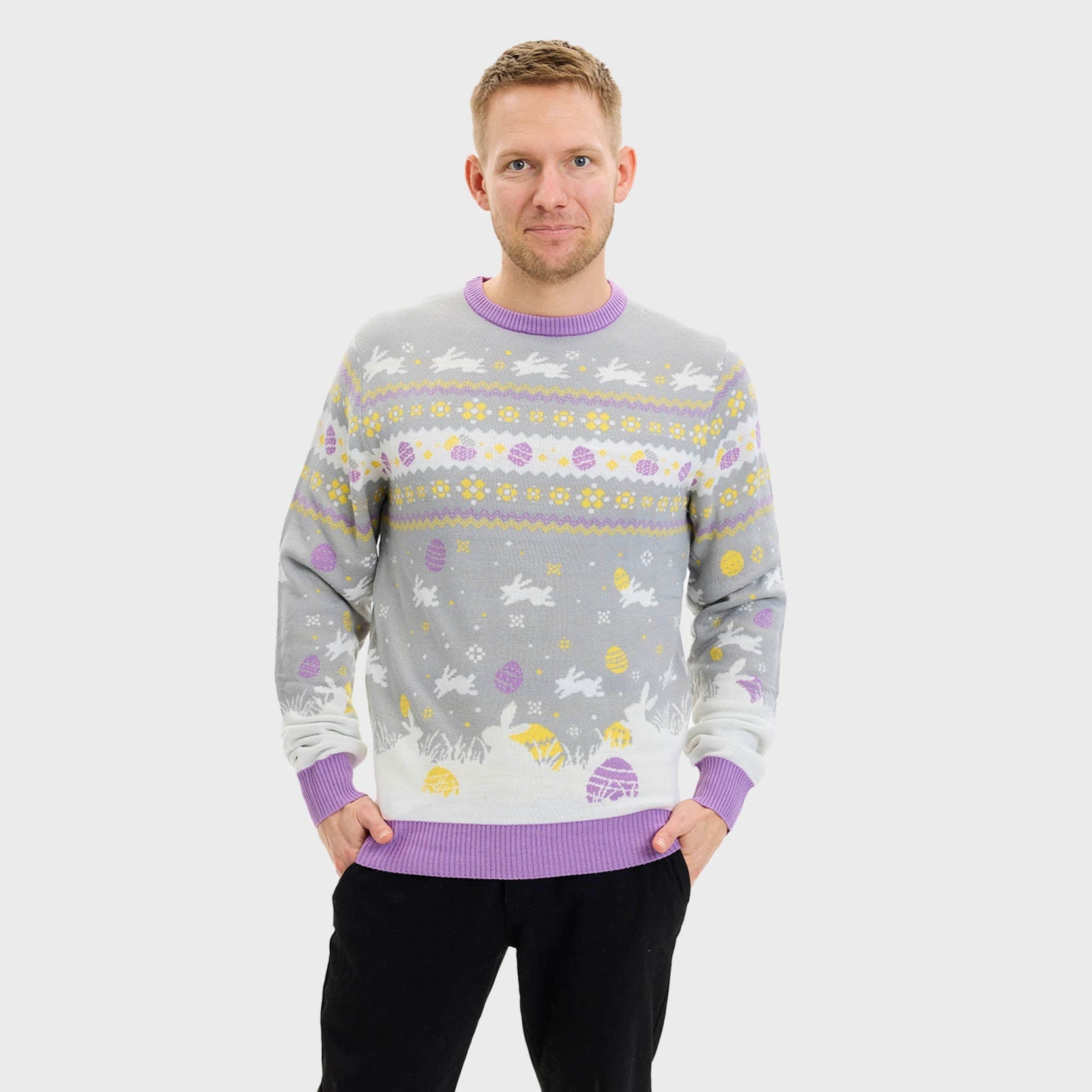 En smilende mann har på seg en grå påskegenser med kaniner på.